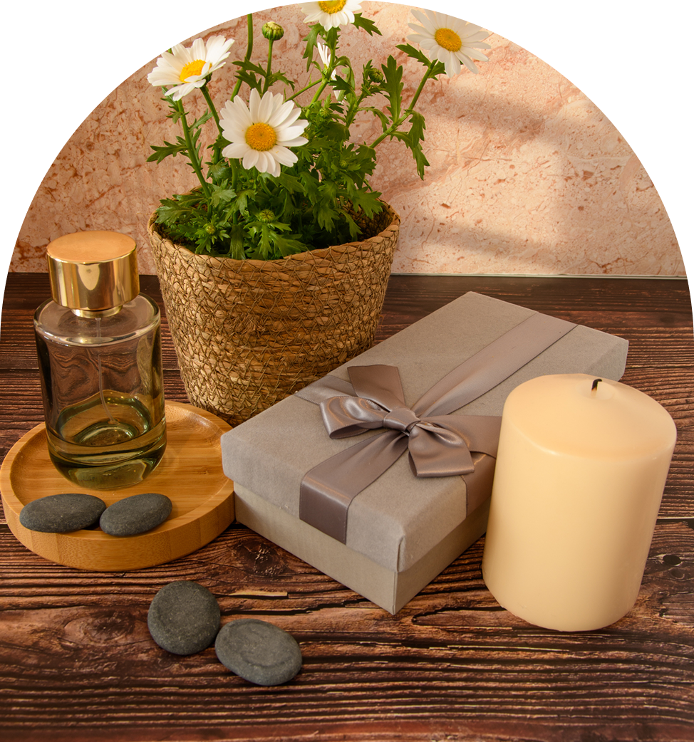 Gift box, candle, daisies, stones, and perfume.